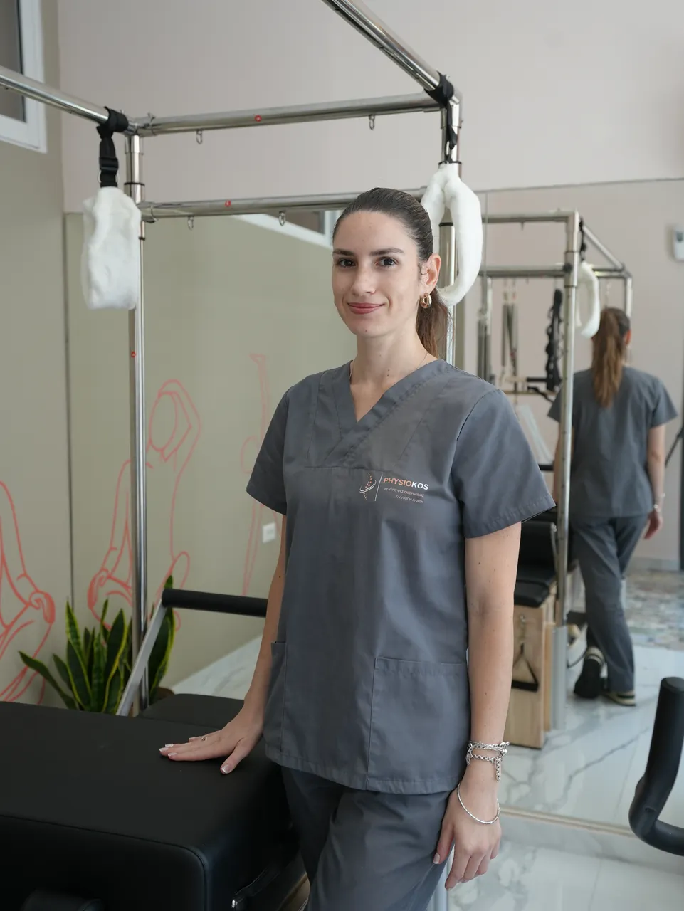 Φυσικοθεραπεύτρια του PhysioKos δίπλα στο reformer του Clinical Pilates
